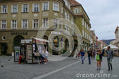 A magazine selling kiosk and the Coroana hotel behind it in Brasov. Editorial Stock Photo