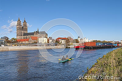 Magdeburg historical downtown, Elbe river, the ancient medieval cathedral with coming by big cargo container ship, barge, in Editorial Stock Photo