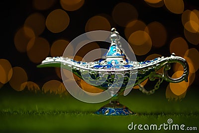 Magic Aladdin lamp of wishes on soft yellow lights background. Fairy tale concept Stock Photo