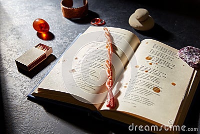 Magic book, wax candle, matches and gem stones Stock Photo