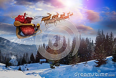 Magic Christmas eve. Santa with reindeers flying in sky Stock Photo