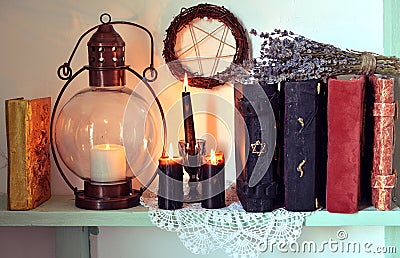 Burning black candles, old-fashioned lamp and pentagram Stock Photo