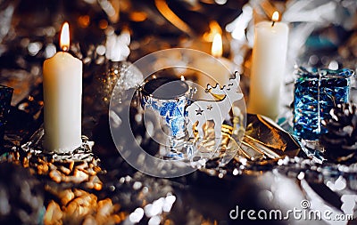 Magic little deer standing near decorative drum between pine cones and burning candles. Christmas night celebration Stock Photo