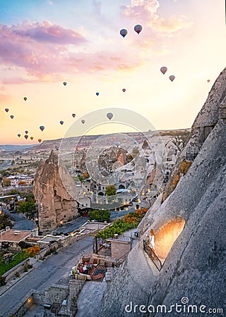 Magic morning in Cappadocia - a woman on the cave balcony watching an amazing morning flight of balloons Editorial Stock Photo