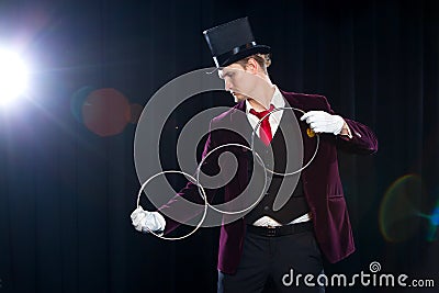 Magic, performance, circus, show concept - magician in top hat showing trick with linking rings Stock Photo