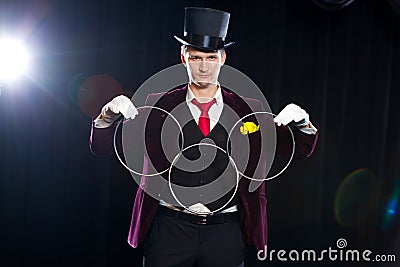Magic, performance, circus, show concept - magician in top hat showing trick with linking rings Stock Photo