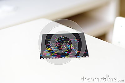 Close up of magic scratch painting paper on white table at home. Stock Photo