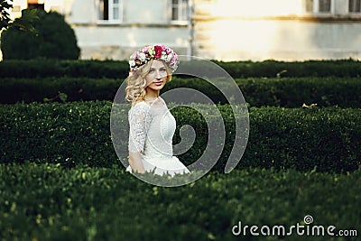 Magical beautiful young blonde bride in elegant dress walking in Stock Photo