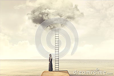Surreal moment of woman climbing an imaginary scale to the clouds Stock Photo