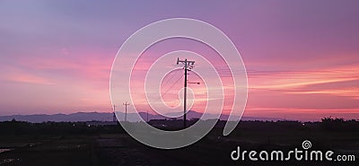 Magical Twilight: Electricity Poles Welcome Purple Twilight Stock Photo
