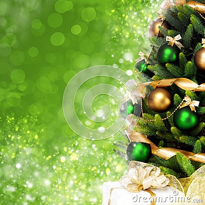 Magically decorated Christmas Tree with balls, ribbons and golden garlands on a blurred green shiny background Stock Photo