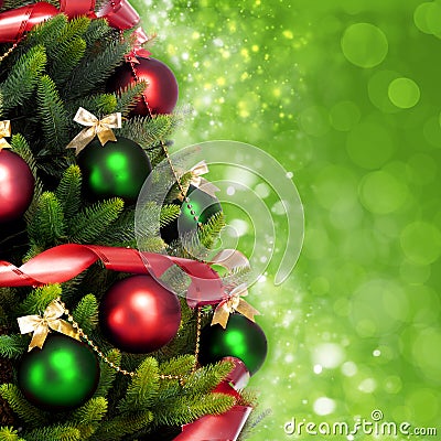 Magically decorated Fir Tree with balls, ribbons and garlands on a blurred Christmas-green shiny and sparkling background. Stock Photo