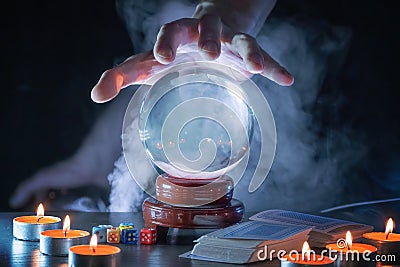 Magician or fortune teller is predicting future with crystal sphere. Stock Photo