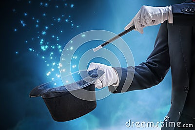 Magician or illusionist is showing magic trick. Blue stage light in background Stock Photo