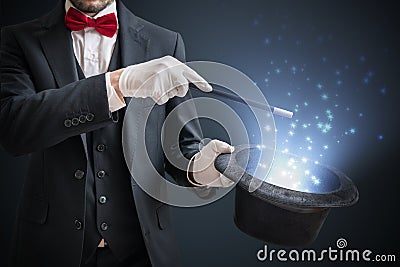 Magician or illusionist is showing magic trick. Blue stage light in background Stock Photo