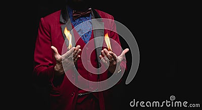 Magician shows trick with fire burn from palms hands Stock Photo