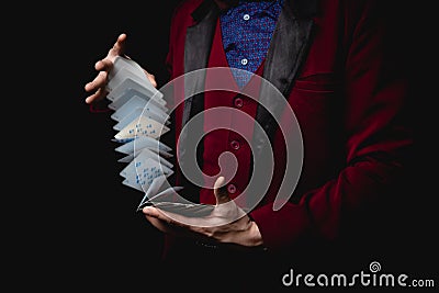 Magician shows trick with playing cards, dark background Stock Photo