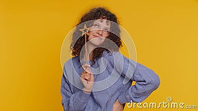 Magician witch young woman gesturing with magic wand making wish come true, casting magician spell Stock Photo