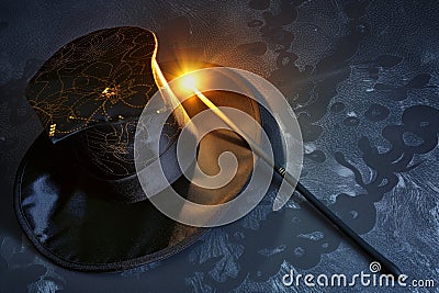 magicians hat lying on its side, wand with a glowing tip nearby Stock Photo