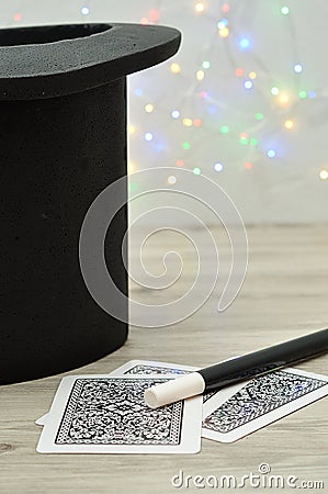 A magicians hat, wand and cards against an out of focus light background Stock Photo