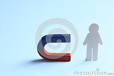 Magnet attracting paper person on blue background Stock Photo