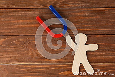 Magnet and paper person on wooden table Stock Photo