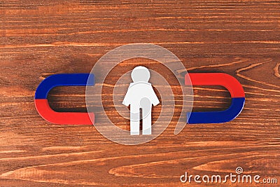 Magnets and paper person on wooden table Stock Photo