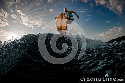 magnificent bottom view of male wakeboarder while jumping over splashing wave Stock Photo