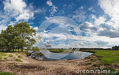 Magnificent panoramic spring-summer landscape with lonely fisherman, river and a beautiful cloudy sky. Stock Photo