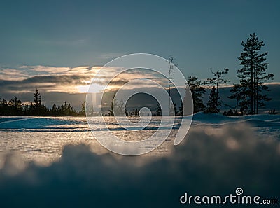 Magnificent photo of vertical light orange Sun beam shining from behind of heavy clouds down to pine tree forest. Winter snowy Stock Photo