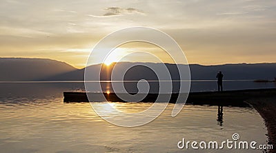 Magnificent scenery .man picturing sunset over lake prespa in macedonia Stock Photo