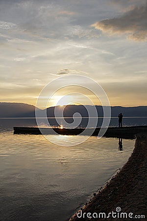 Magnificent scenery .man picturing sunset over lake prespa in macedonia Stock Photo
