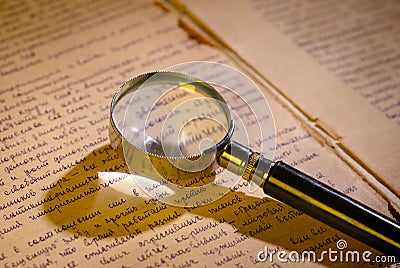Magnifier glass on page of ancient manuscript Stock Photo