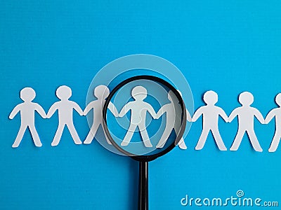 Magnifying glass and figurines of people searching for job candidates Stock Photo