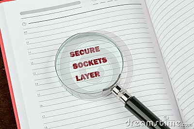 A magnifying glass focuses on the text secure sockets layer in bold letters on an open notebook, highlighting the Stock Photo