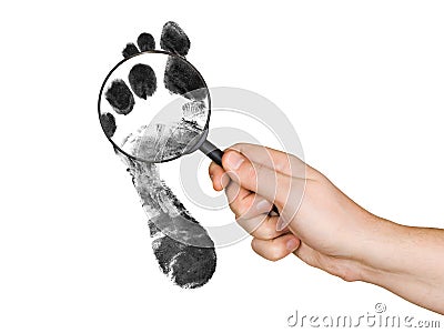 Magnifying glass in hand and foot printout Stock Photo