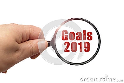 Magnifying glass in hand and a Goals 2019 text on the white background Stock Photo