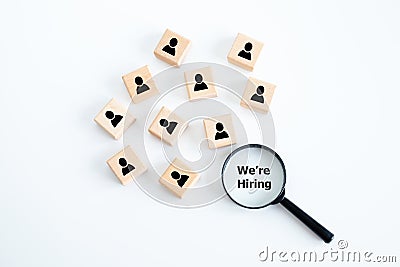 Magnifying glass looking for employees on wood cube. Human resources management and recruitment business hiring concept. Stock Photo