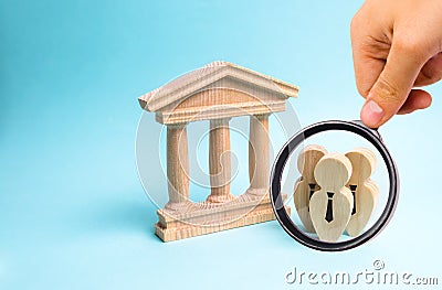 Magnifying glass is looking at the Figures of people in ties stand near the government building or the court, the bank. Officials Stock Photo