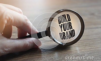 Magnifying glass with text Build Your Brand. Marketing business concept Stock Photo