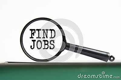 magnifying glass with text find jobs on notebook Stock Photo
