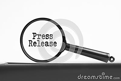 magnifying glass with text press release on notebook Stock Photo