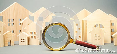 Magnifying glass and wooden houses. House searching concept. Home appraisal. Property valuation. Choice of location for the Stock Photo
