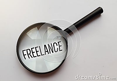 Magnifying glass with the word freelance. Distant job working online business concept Stock Photo