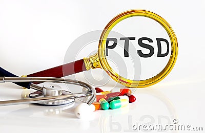 Magnifying lens with text PTSD with medical tools Stock Photo