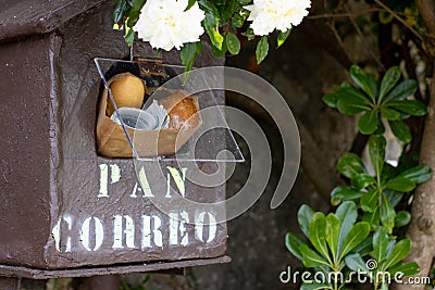 A mailbox with fresh bread and newspaper inside Stock Photo