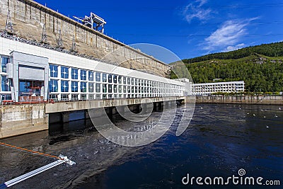 The main building with turbines of the Zeya hydroelectric station on the background of a concrete dam. Stock Photo