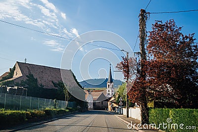 Main street with Rorschwihr village in Alsace with mountains and Eglise Saint Stock Photo