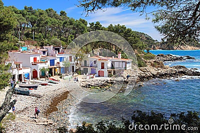 Main view of cala s`Alguer, a lovely beach surrounded by traditional fishermen`s white buildings with colorful doors and windows. Editorial Stock Photo