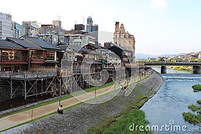 Main view of Kamo river promenade with many terraces of restaurants and bars with Kyoto`s old town buildings on background Editorial Stock Photo